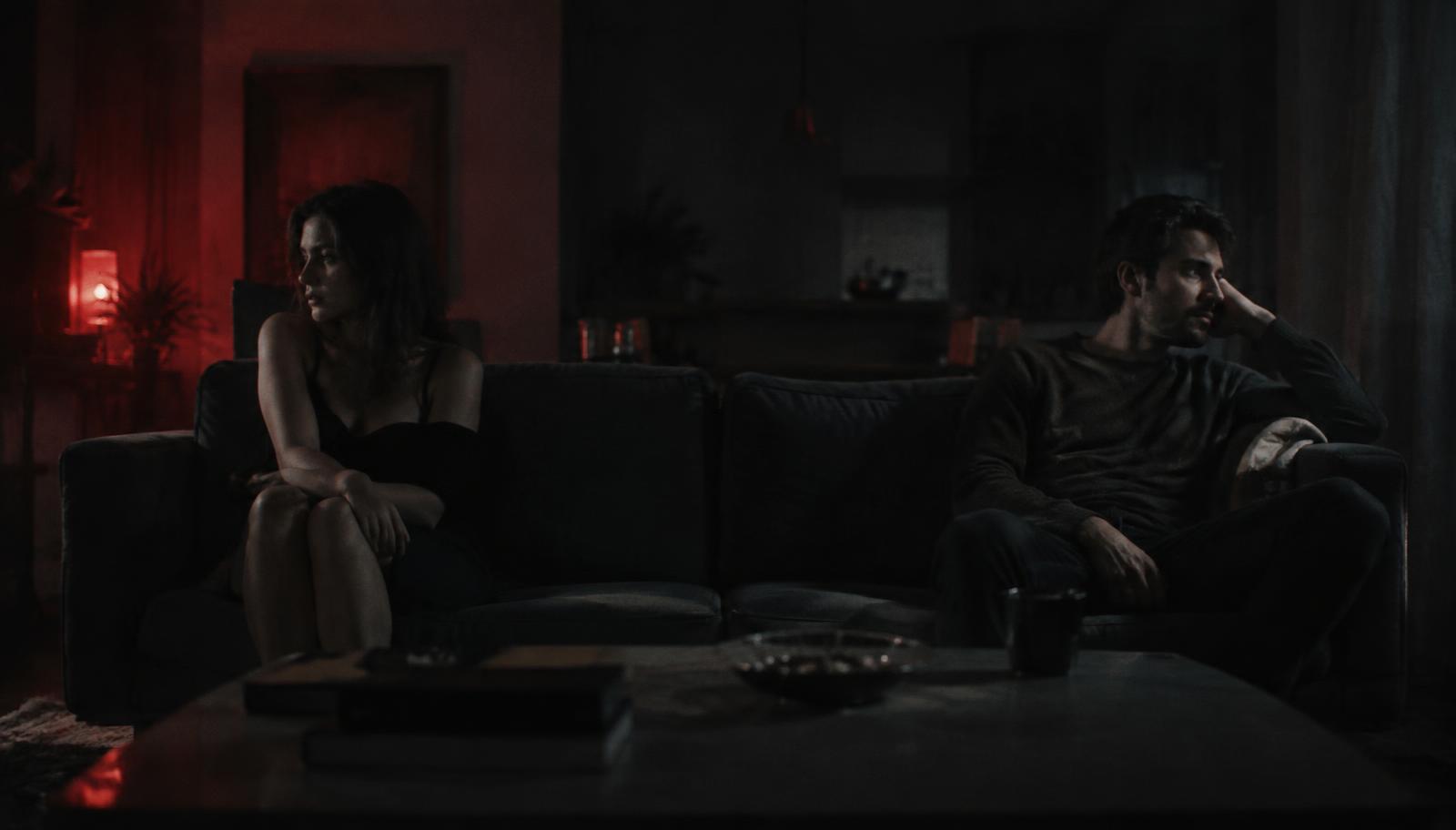 Casal distante em uma sala escura